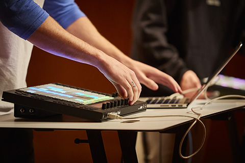 A laptop and drum machine in use